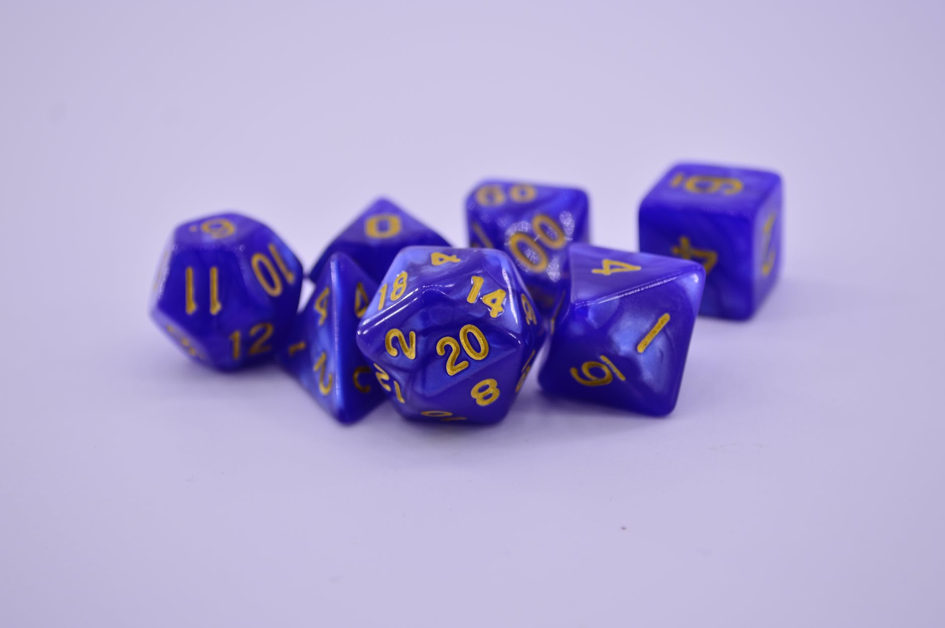 purple dices with different geometrical shape on a white surface